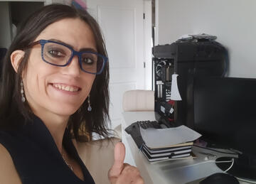 Erin Bennet, Co-Founder and CISO of SECRT LLC, smiling at her desk with computer equipment in the background.